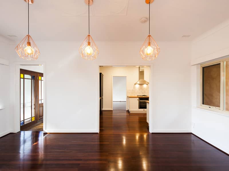 An empty but renovated living area with three new down lights.