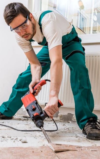 A man removing old tile with jackhammer