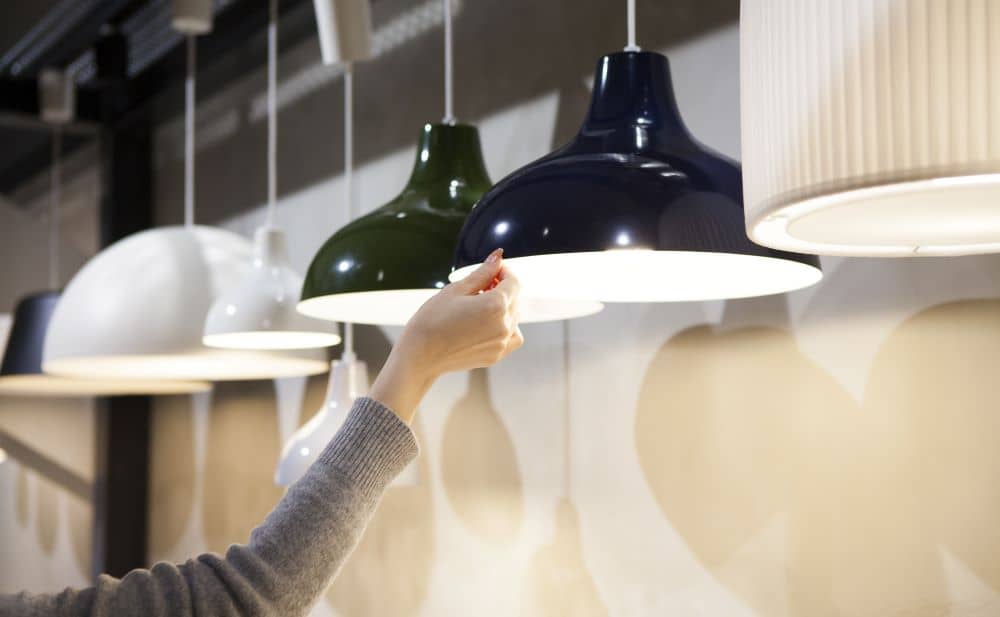 Woman's hands, selecting light fixture. 